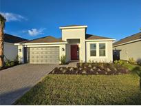 New single-story home with gray garage door and red front door at 16105 Old Fox Trl, Port Charlotte, FL 33953