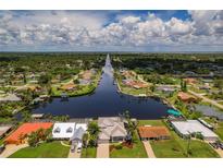 Beautiful aerial view of waterfront homes on canal with lush landscaping and access to bay at 4440 Tatum St, Port Charlotte, FL 33948