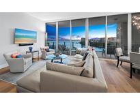 Spacious living room boasts stunning water views & modern furniture at 1155 N Gulfstream Ave # 703, Sarasota, FL 34236