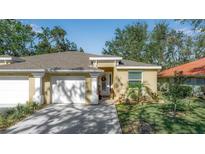 Front view of charming house with two-car garage and manicured lawn at 128 51St Street E Cir # 7, Palmetto, FL 34221