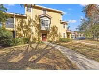 Tan two-story townhome with red garage doors and walkway at 4990 Baraldi Cir # 101, Sarasota, FL 34235