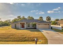 Newly constructed one-story home with attached garage and spacious lawn at 5271 Beckham St, North Port, FL 34288