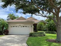 Charming single-story home features a well-manicured lawn, mature trees, and an attached two-car garage at 11129 Sanctuary Dr, Bradenton, FL 34209