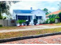 Charming bungalow with white exterior, landscaping, and brick walkway at 3642 Dartmouth N Ave, St Petersburg, FL 33713