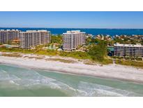 Aerial view of luxurious beachfront condo building with resort amenities at 1211 Gulf Of Mexico Dr # 408, Longboat Key, FL 34228