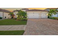 Two-story home with tile roof, two-car garage, and landscaped yard at 20717 Benissimo Dr, Venice, FL 34293