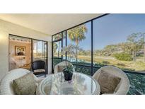 Relaxing screened patio with seating area and scenic golf course view at 4410 Weybridge # 91, Sarasota, FL 34235