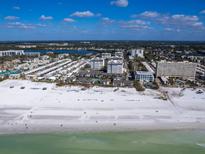 Aerial view of beachfront property, showing community, beach, and ocean at 1080 W Peppertree Ln # 506A, Sarasota, FL 34242
