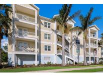 Building exterior featuring three-story, light-yellow building with balconies and palm trees at 3431 79Th Street W Cir # 102, Bradenton, FL 34209