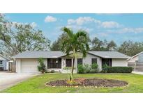 Attractive single-story home with gray and white exterior, landscaping, and a palm tree at 6201 34Th W Ave, Bradenton, FL 34209