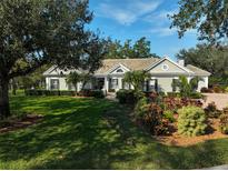 Beautiful one-story home with lush landscaping and a large lawn at 85 Sugar Mill Dr, Osprey, FL 34229