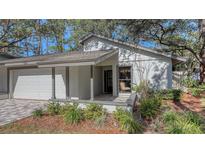 Updated exterior featuring a two-car garage and landscaped grounds at 4720 Oak Forest W Dr # 57, Sarasota, FL 34231