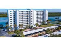 Condo building with parking, landscaping, and waterfront access at 9393 Midnight Pass Rd # 201, Sarasota, FL 34242