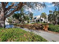 Fairway Bay condos showcasing lush landscaping, mature trees and white buildings with blue accents at 1912 Harbourside Dr # 603, Longboat Key, FL 34228