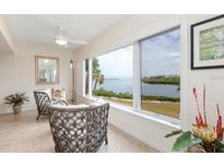 Bright living room with water views and comfy wicker chairs at 3330 Gulf Of Mexico Dr # 205D, Longboat Key, FL 34228