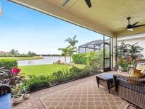 Spacious screened porch overlooking lake with wicker furniture at 4925 Surfside Cir, Bradenton, FL 34211