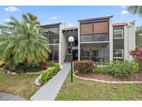 Exterior view of the condo building with landscaping at 3213 Beneva Rd # 201, Sarasota, FL 34232