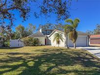 House exterior with landscaped yard, driveway, and attached garage at 8224 Country Oaks Ct, Sarasota, FL 34243