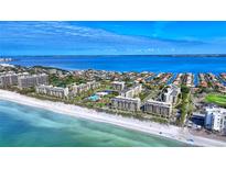 Aerial view of a waterfront condo building with a beautiful beach and water at 1065 Gulf Of Mexico Dr # 201, Longboat Key, FL 34228