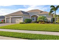 Beautiful one-story home with three-car garage, lush lawn, and mature landscaping at 11907 Petunia Ter, Bradenton, FL 34212