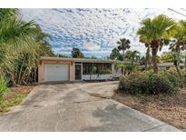 Pink house with carport and screened porch at 219 Periwinkle Plz, Anna Maria, FL 34216