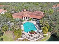 Aerial view of a large community pool featuring ample seating surrounded by lush landscaping and palm trees at 4178 Central Sarasota Pkwy # 316, Sarasota, FL 34238