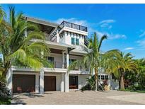 Stunning two-story home with a spacious driveway and lush landscaping at 9403 Gulf Dr, Anna Maria, FL 34216