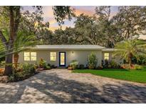 Newly renovated home with a metal roof, paved driveway, and landscaped yard at 730 40Th St, Sarasota, FL 34234