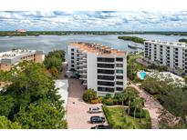 Aerial view of waterfront condo building with pool and parking at 8701 Midnight Pass Rd # 106A, Sarasota, FL 34242