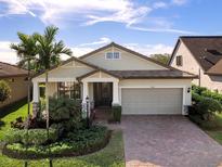 One-story home with light beige siding, brown roof, and a brick driveway at 17208 Corinna Pl, Lakewood Ranch, FL 34202