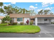 Front view of charming house with carport and well-manicured lawn at 2729 Riverbluff Ct # V93, Sarasota, FL 34231