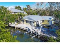 Aerial view of waterfront home with private dock and boat lifts at 563 Juan Anasco Dr, Longboat Key, FL 34228