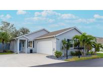 Newly built home with gray siding, two-car garage, and landscaped front yard at 639 Ironwood Cir # 144, Venice, FL 34292