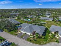 Aerial view of villa, landscaped grounds, and community pool at 6946 W Country Club N Dr, Sarasota, FL 34243