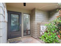 Inviting front entrance with a black door and lush landscaping at 1704 Pelican Cove Rd # T138, Sarasota, FL 34231