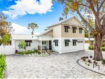 Stunning two-story home with a gray and white exterior, landscaping, and a paved driveway at 2326 Gull Ln, Sarasota, FL 34237