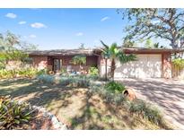 Ranch style home with mature landscaping and a brick driveway at 2531 Wilkinson Rd, Sarasota, FL 34231