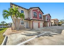 Tan and red two-story building, attached garages, and palm trees at 1323 Mediterranean Dr # 111, Punta Gorda, FL 33950