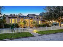 Evening view of charming two-story house with white picket fence and landscaping at 1714 Irving St, Sarasota, FL 34236