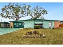 Ranch-style home with green exterior, mature trees, and landscaped yard at 1000 Dartmouth Dr, Bradenton, FL 34207