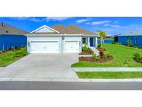 Single-story home with two-car garage, landscaped yard, and lake view at 14316 Skipping Stone Loop, Parrish, FL 34219