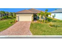 Single-story home with tile roof, paver driveway, and landscaped lawn at 7675 Summerland Cv, Bradenton, FL 34202