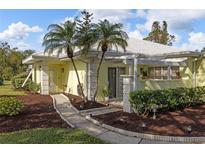 Light yellow house exterior with palm trees and walkway at 310 Wexford Ter # 164, Venice, FL 34293