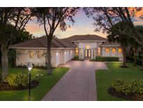 Luxury home with brick driveway, three-car garage, and landscaped yard at 3769 Caledonia Ln, Sarasota, FL 34240