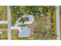 A tranquil treed setting surrounds this lovely home with a long driveway and backyard fire pit at 4801 Brickell Dr, North Port, FL 34286