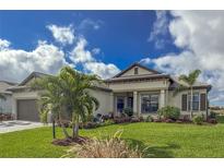 Single-story home with a two-car garage and lush landscaping at 4820 Coastal Days Ln, Bradenton, FL 34211