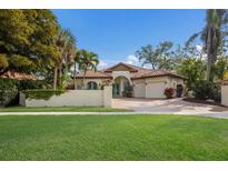 Elegant single-story home with a clay tile roof, turquoise doors, a lush lawn, and a two-car garage at 4946 Brywill Cir, Sarasota, FL 34234