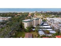 Aerial view of a condo building near the beach, with ample parking and lush landscaping at 512 W Venice Ave # 401, Venice, FL 34285