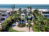 Beachfront property with circular driveway, lush landscaping, and ocean views at 6161 Gulf Of Mexico Dr, Longboat Key, FL 34228