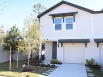 Two-story townhome with gray door, attached garage, and landscaped front yard at 2769 Emory Sound Pl, Brandon, FL 33510
